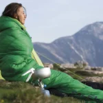 تصویر زنی که کیسه خواب پوشیده در هوای سرد کوهستان