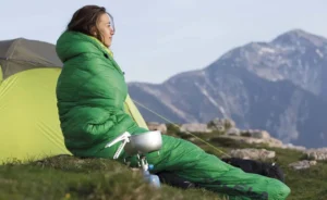 تصویر زنی که کیسه خواب پوشیده در هوای سرد کوهستان